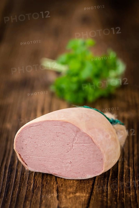 Liverwurst (German cuisine) as high detailed close-up shot on a vintage wooden table (selective focus)