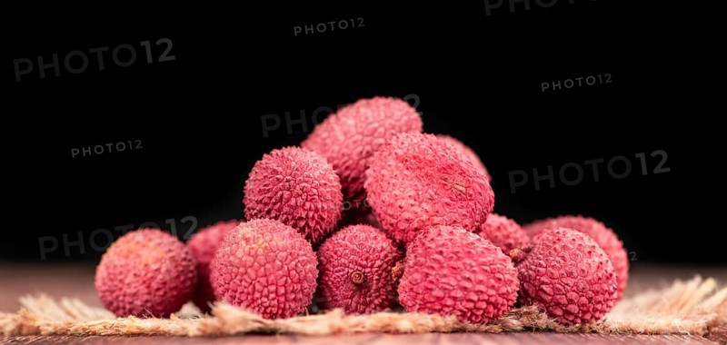 Litchis on an old wooden table as detailed close-up shot (selective focus)