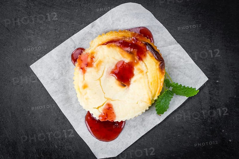 Fresh made Mini Cheesecake (with Sauce) on a vintage background (close-up shot)