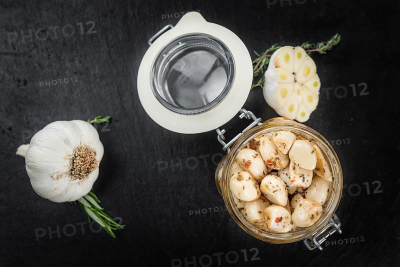 Marinated Garlic on a vintage slate slab (close-up shot, selective focus)