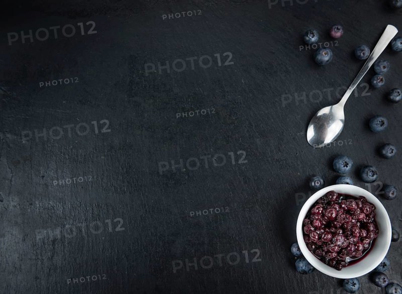 Some fresh Preserved Blueberries on a vintage slate slab, selective focus, close-up shot
