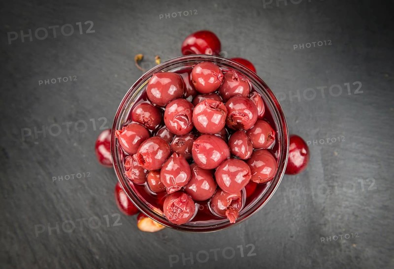 Preserved Cherries on a vintage slate slab as detailed close-up shot, selective focus