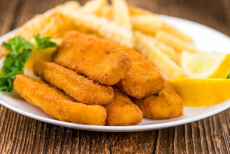 Portion of Fish Fingers (selective focus) on wooden background