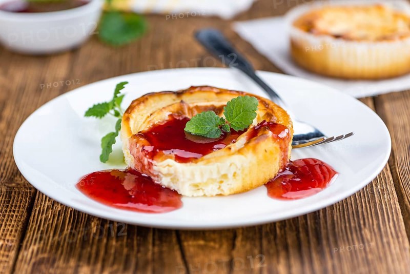 Cheesecake with Sauce on an old wooden table as detailed close-up shot (selective focus)