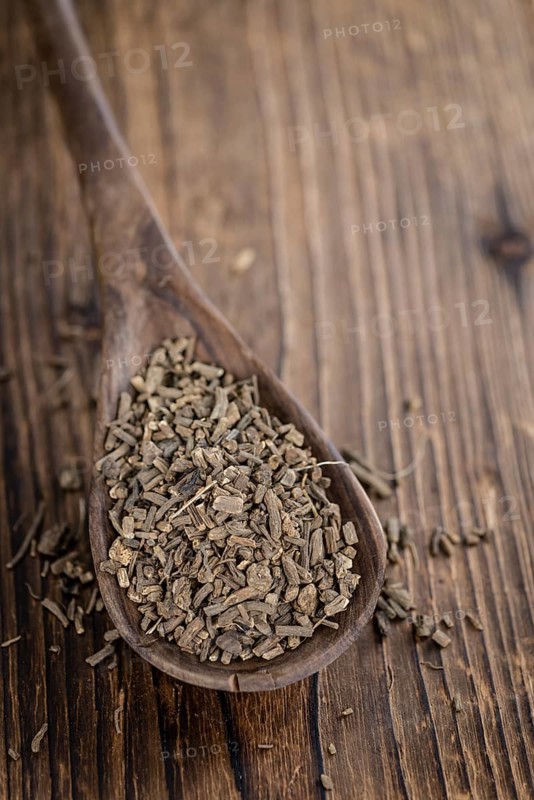 Dried Valerian roots (detailed close-up shot) on wooden background