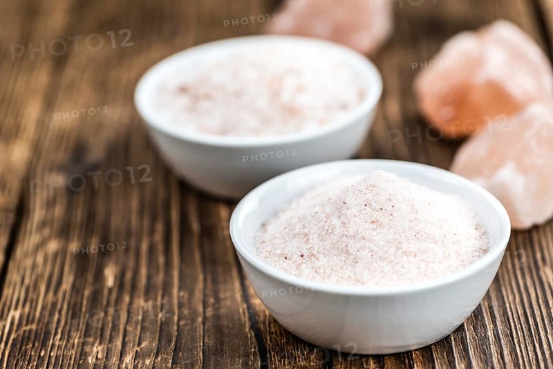 Pink Himalayan Salt on rustic wooden background (close-up shot)