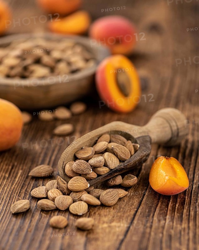 Vintage wooden table with a portion of shelled Apricot Kernels (close up shot, selective focus)