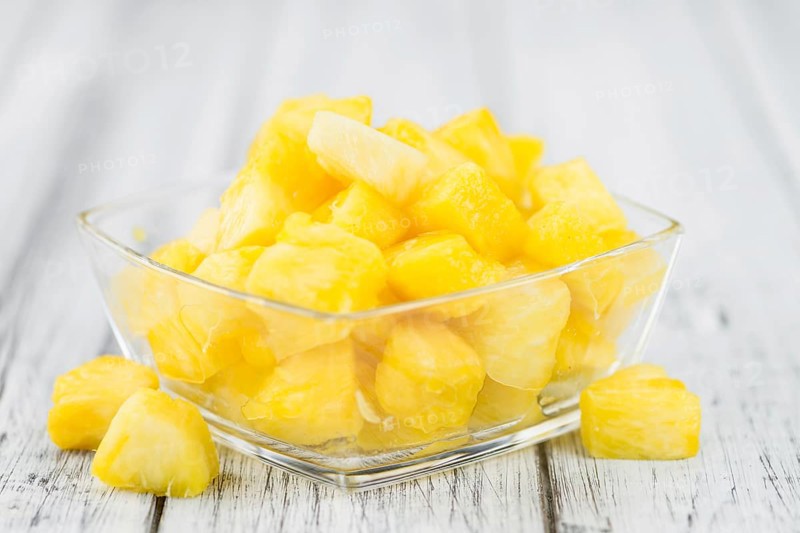 Sliced Pineapple on rustic wooden background as close-up shot