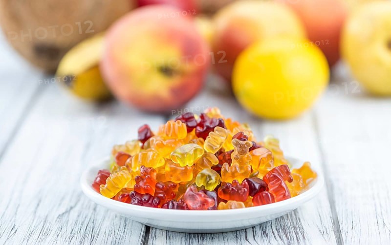 Wooden table with Gummy Bears (close-up shot, selective focus)