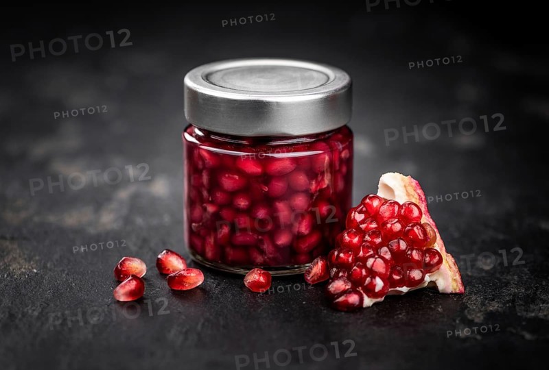 Healthy preserved Pomegranate seeds on a vintage slate slab (close-up shot, selective focus)