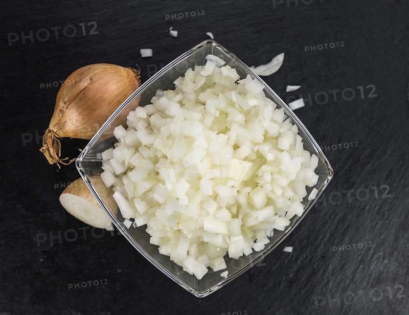 Portion of Chopped white onions as detailed close up shot on a slate slab, selective focus