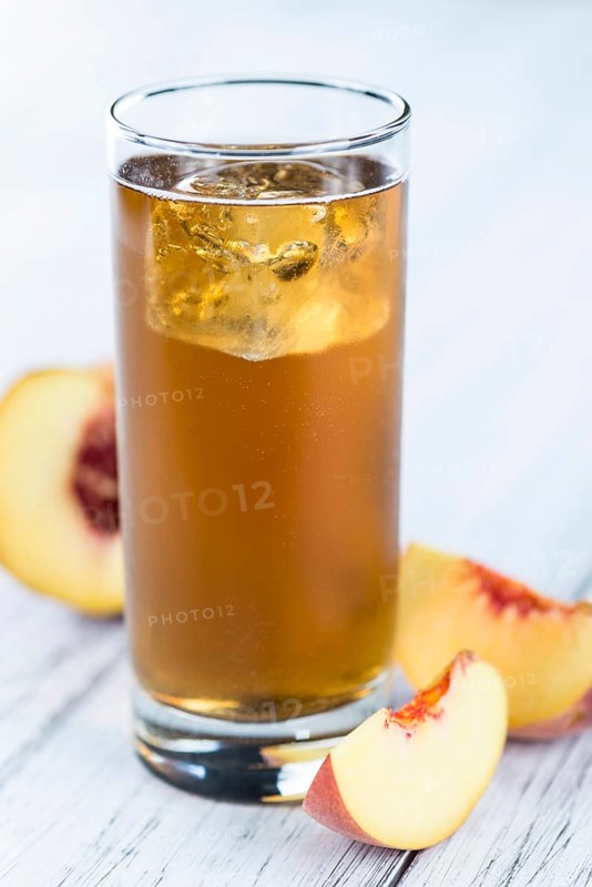Ice Tea (Peach) on an old wooden table (selective focus, close-up shot)
