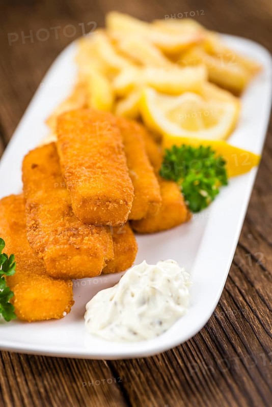 Some fried Fish Sticks (selective focus) on an old wooden table