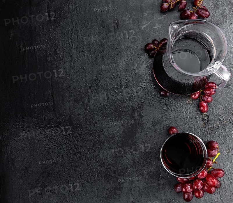 Portion of healthy Red Grape Juice on a slate slab (selective focus)