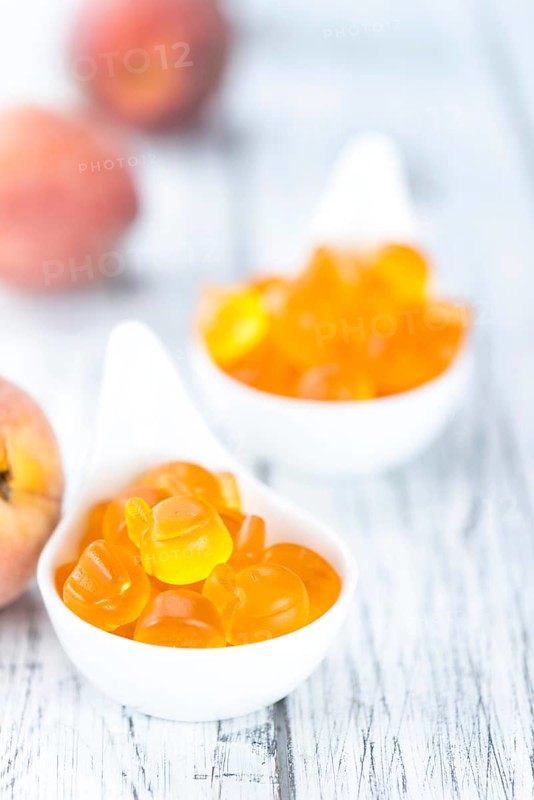 Gummy Peaches (detailed close-up shot) on an old wooden table