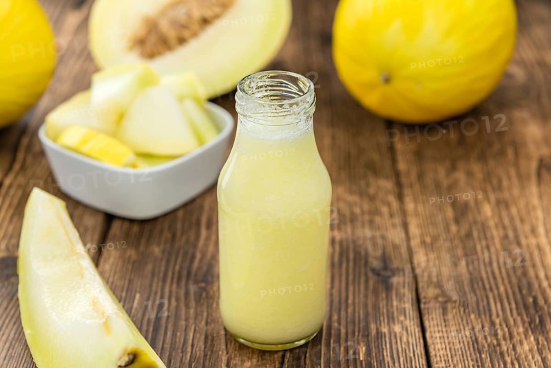 Fresh made Honeydew Melon smoothie (close-up shot, selective focus) on a wooden table