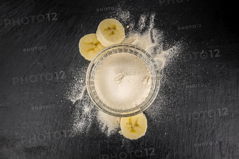 Portion of Banana Powder as detailed close up shot on a slate slab, selective focus
