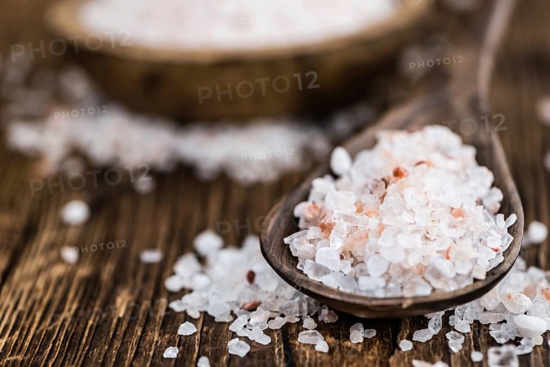 Himalayan Salt as high detailed close-up shot on a vintage wooden table (selective focus)