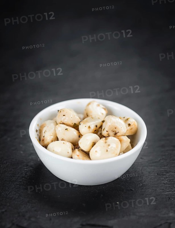 Portion of Garlic (preserved) on a rustic slate slab (selective focus, close-up shot)