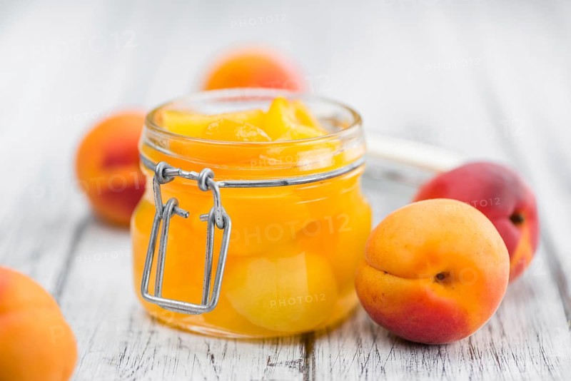 Canned Apricots on an old wooden table as detailed close-up shot (selective focus)