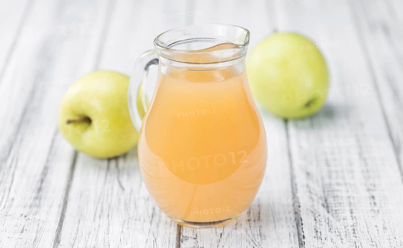 Apple Juice on an old wooden table as detailed close-up shot (selective focus)