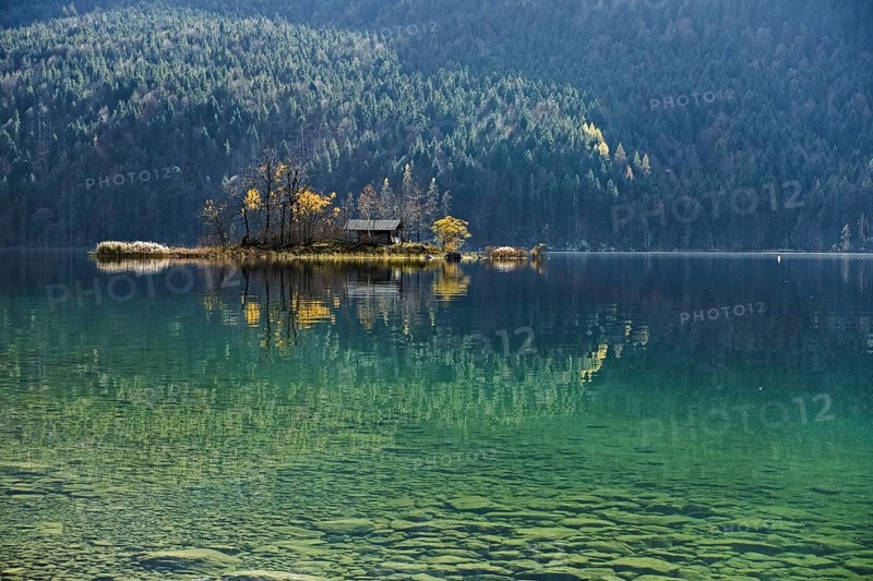 Island with wooden hut in autumn in Lake Eibsee lake in the Bavarian Alps