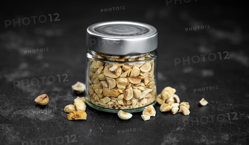 Freshly chopped Hazelnuts as detailed close up shot (selective focus)