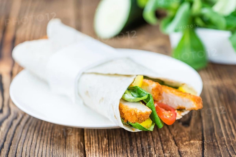 Chicken Wrap (detailed close-up shot, selective focus) on wooden background