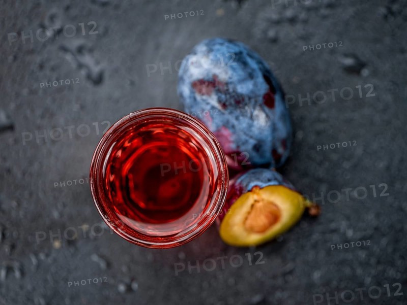 Some Plum Liqueur on a vintage slate slab, selective focus