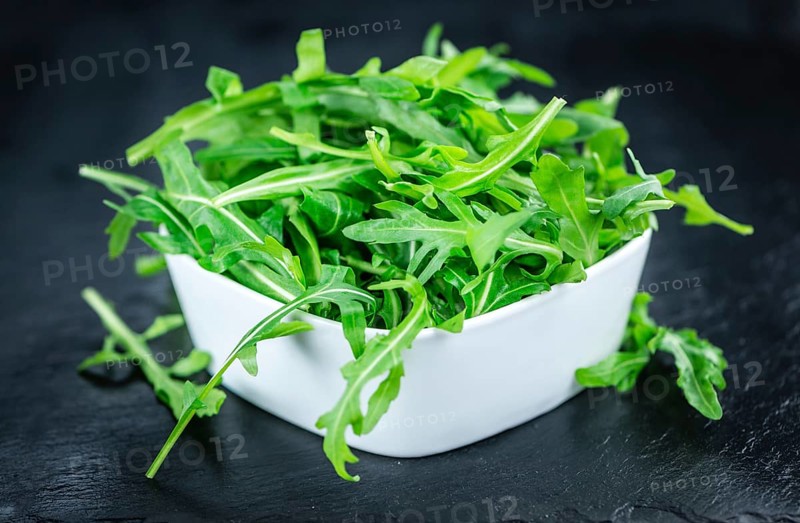 Fresh Arugula (selective focus) as detailed close-up shot on vintage background