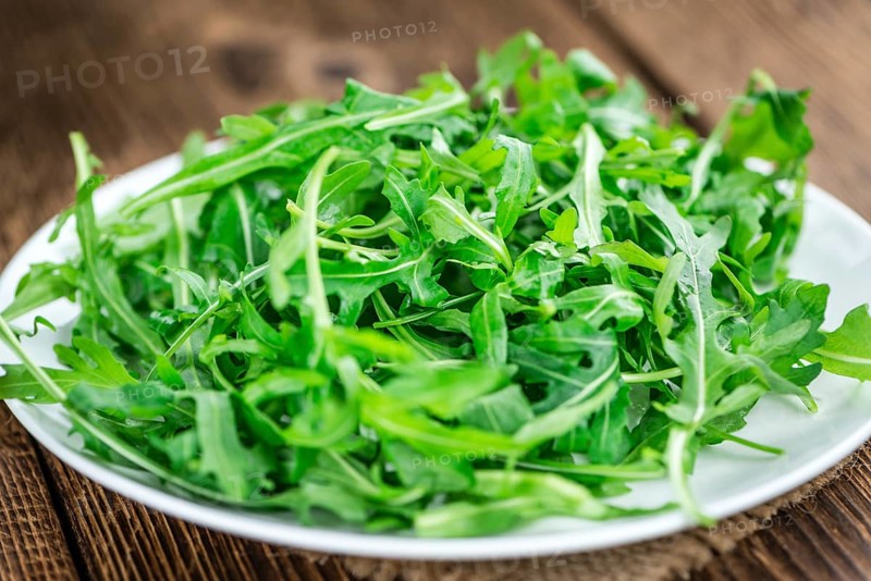 Fresh Arugula on an old wooden table as detailed close-up shot
