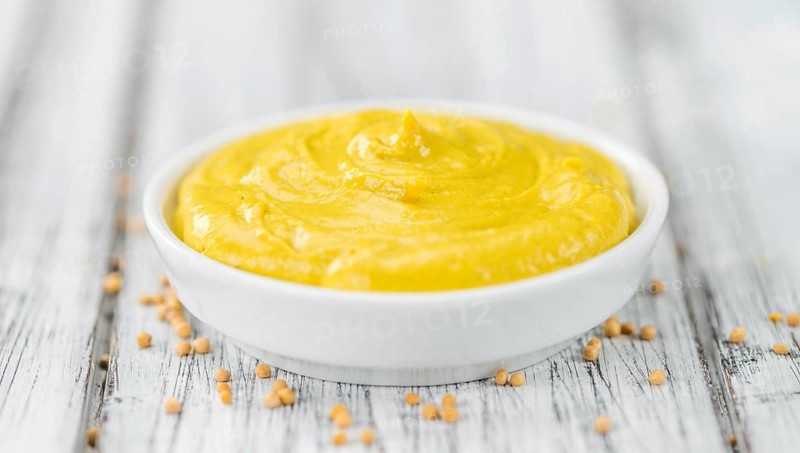 Portion of homemade Mustard on wooden background (selective focus, close-up shot)