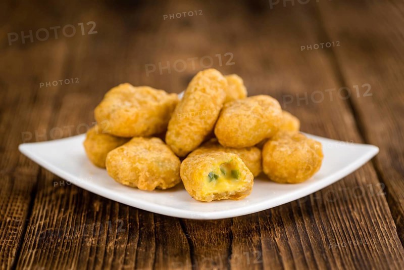 Chili Cheese Nuggets on a vintage background as detailed close-up shot (selective focus)
