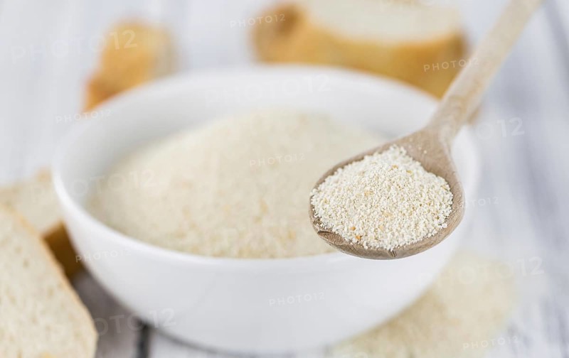 Some Bread Crumbs on a vintage wooden table (selective focus, close-up shot)