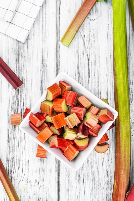 Chopped Rhubarb on an old wooden table (close up shot, selective focus)