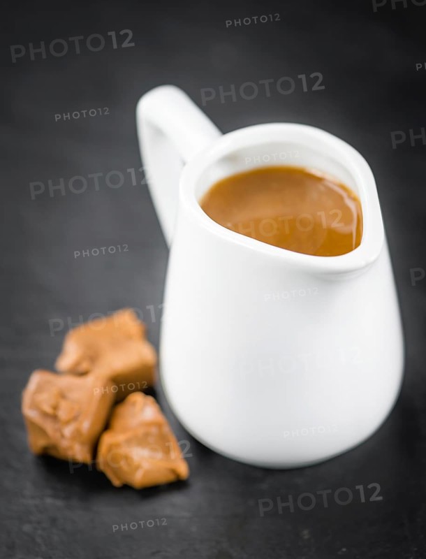 Portion of fresh Caramel Sauce (close-up shot, selective focus)