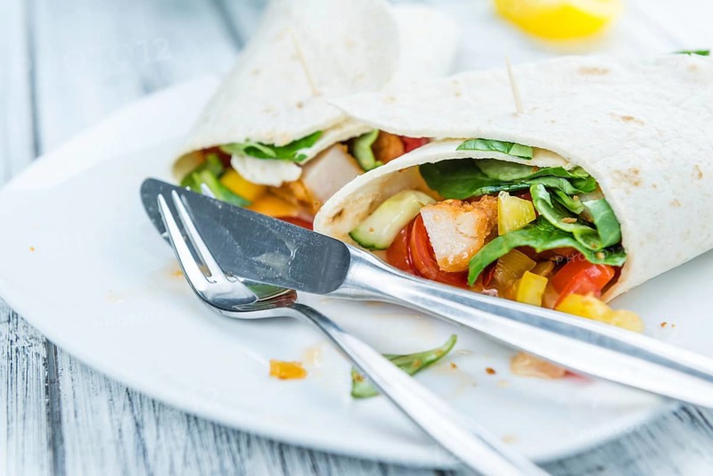 Fresh made Chicken Wraps on an vintage background (selective focus)