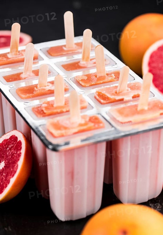 Some freshly made Grapefruit Popsicles (with some fresh fruits, selective focus)