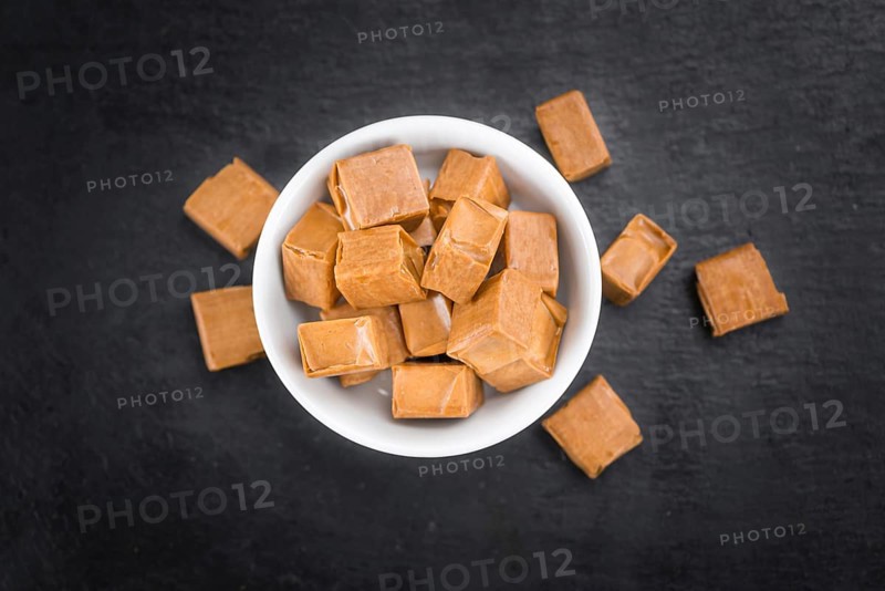 Caramel on a vintage background as detailed close-up shot (selective focus)