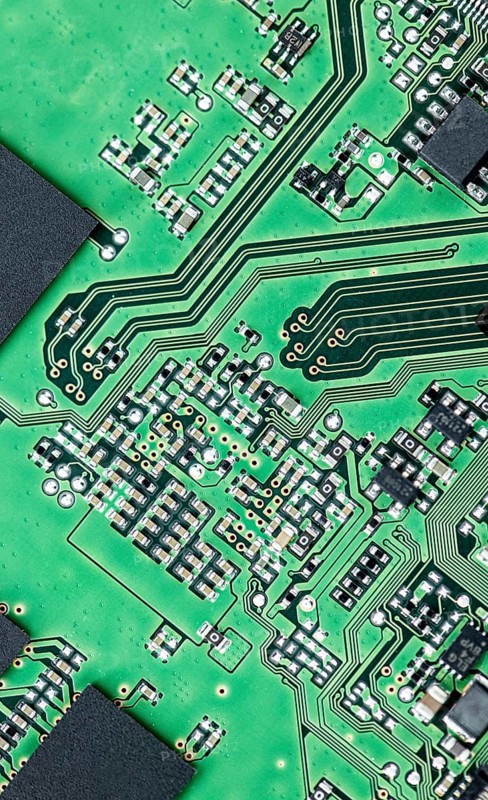 Green printed circuit board (PCB) close-up shot with a lot of electronic components