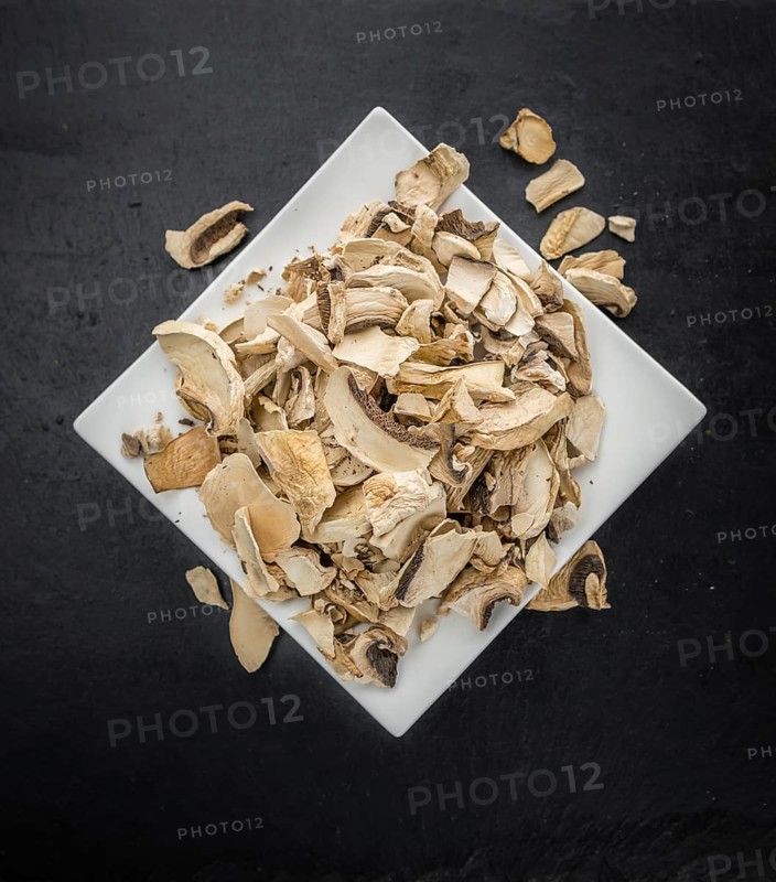 Dried white Mushrooms on a vintage background as detailed close-up shot, selective focus