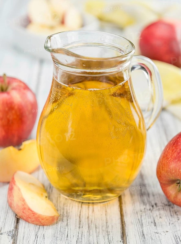 Apple Cider on an old wooden table as detailed close-up shot (selective focus)