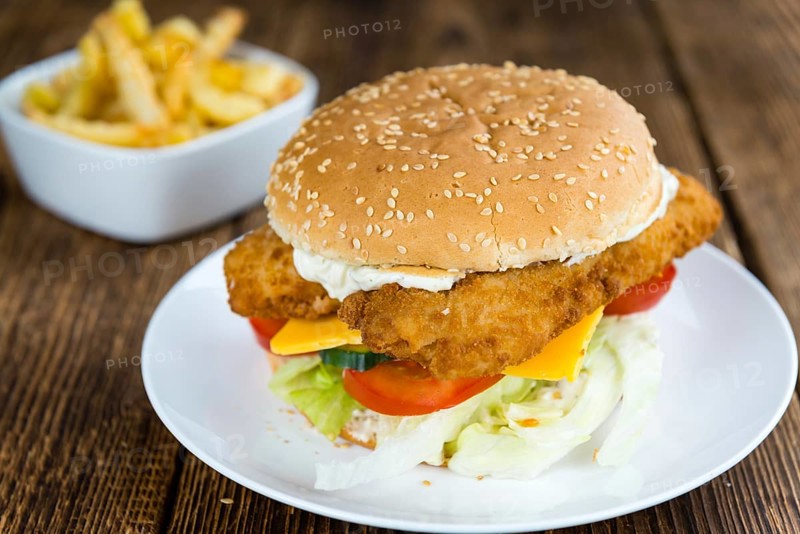 Homemade Fish Burger (close-up shot, selective focus) on a wooden table