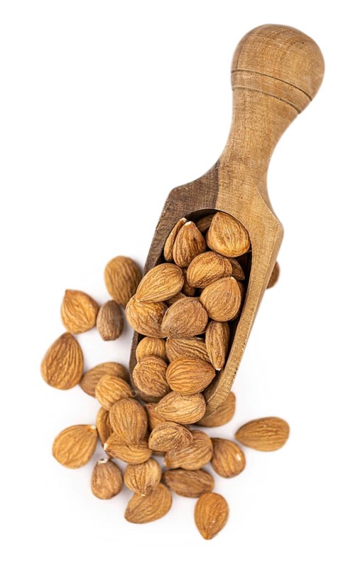 Portion of Apricot Kernels isolated on white background as detailed close up shot (selective focus)