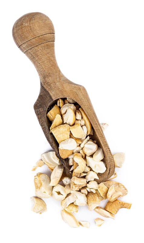 Portion of chopped Cashew nuts isolated on pure white background (detailed close-up shot)