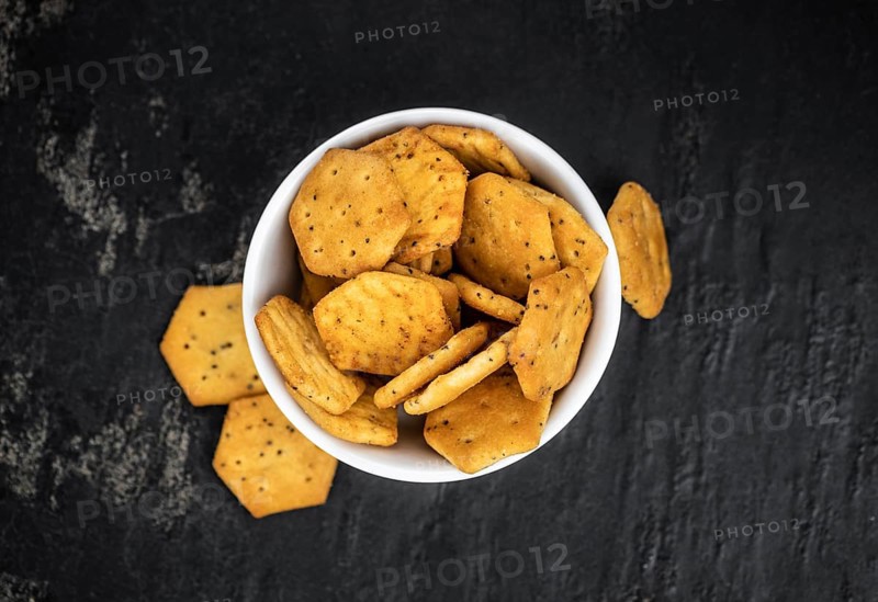 Portion of mixed Snacks on dark background (detailed close up shot, selective focus)