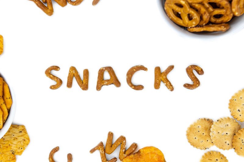 Portion of mixed Snacks isolated on white background (detailed close up shot, selective focus)