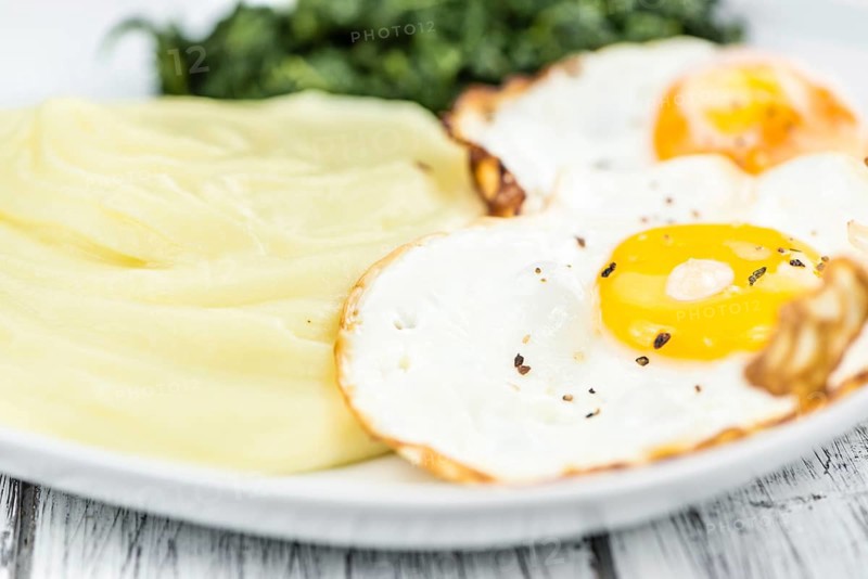 Some homemade Mash (selective focus) as detailed close-up shotwith fried eggs and spinach