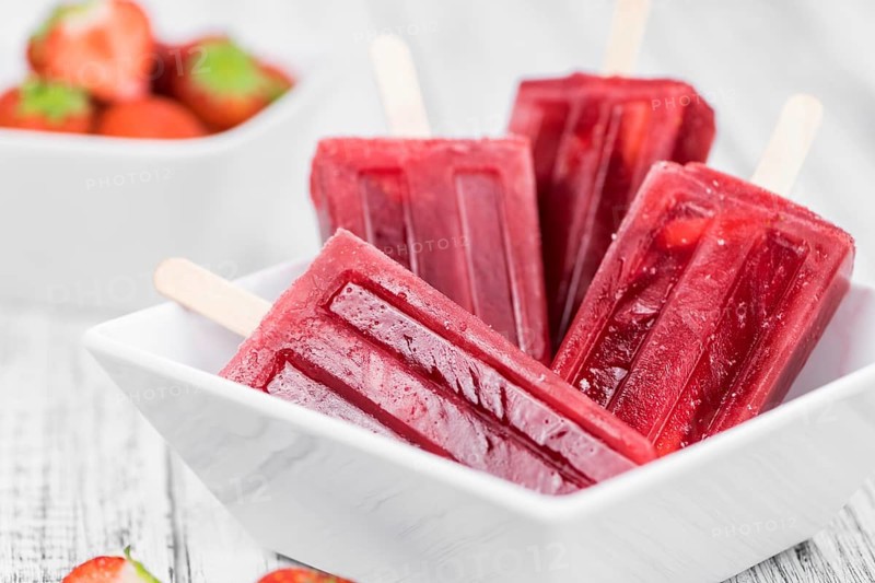 Strawberry Popsicles (close-up shot, selective focus) on a rustic background