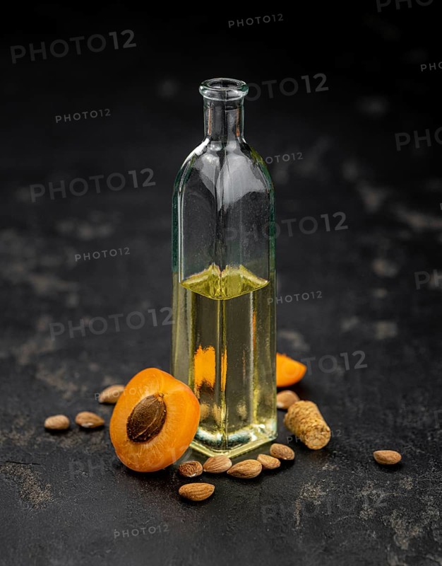 Portion of Apricot Oil with some fresh fruits as detailed close up shot (selective focus)
